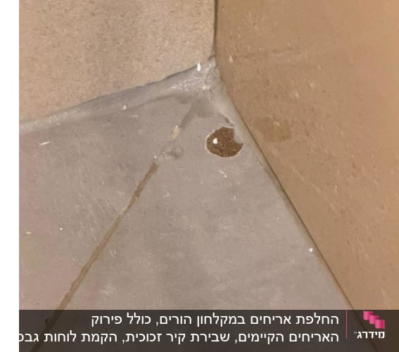תקריב של פגם וחור באריח ריצוף סמוך לקיר